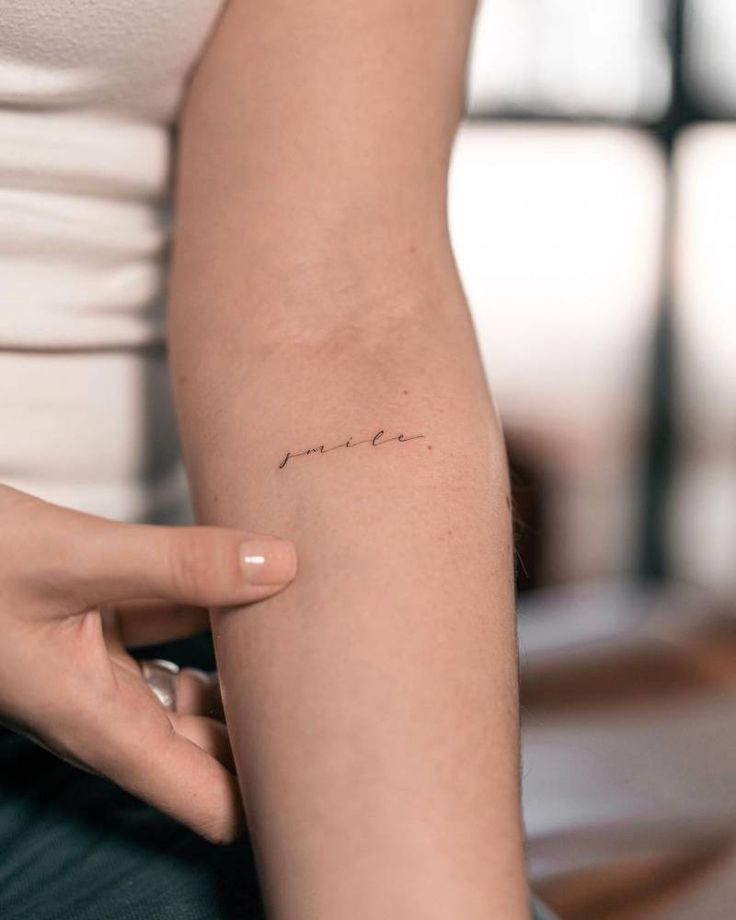 a woman with a small tattoo on her arm that reads, i'm yours