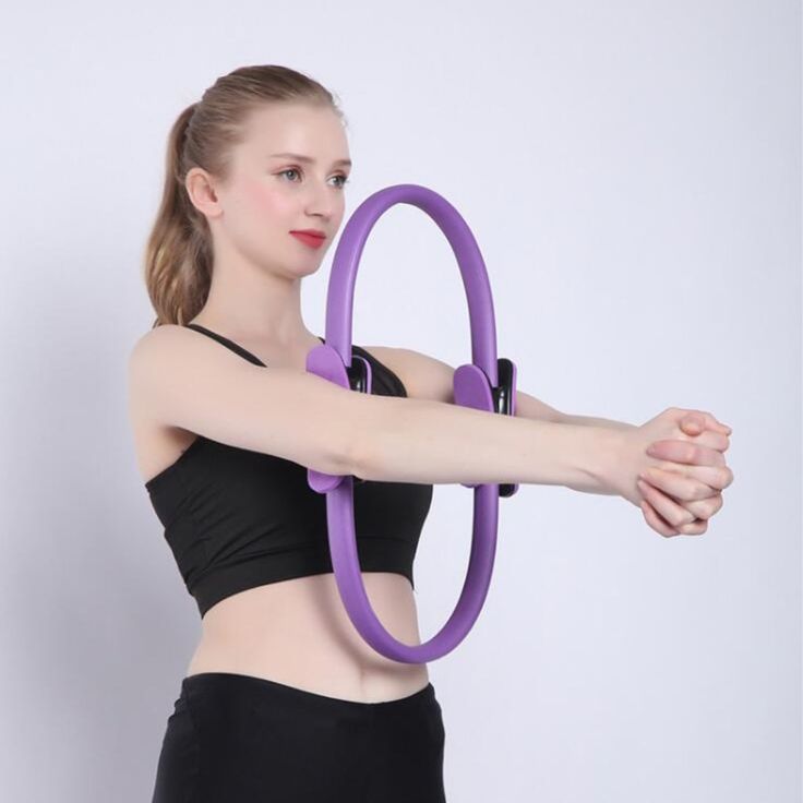 a woman is holding an exercise ring in one hand and her other arm wrapped around it