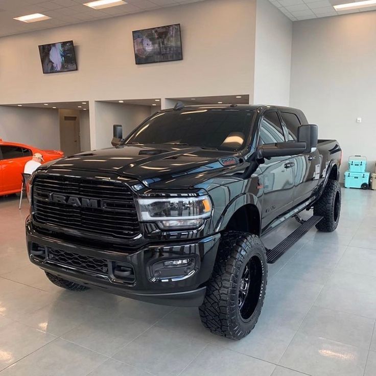 a black truck is parked in a showroom