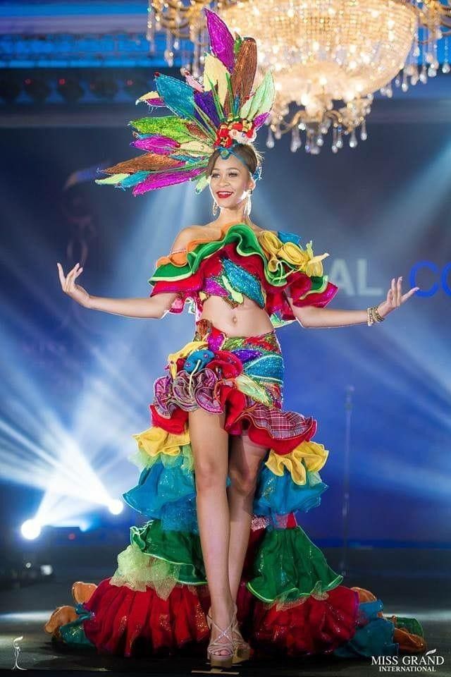 a woman in a colorful dress on the runway