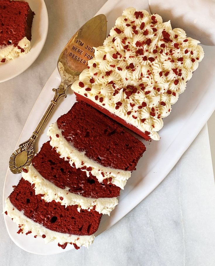 red velvet cake with white frosting and chocolate sprinkles on a plate