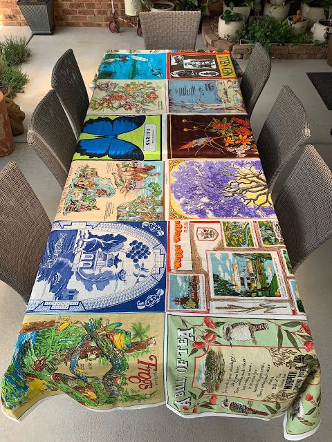 a table covered with lots of different colored plates on top of a floor next to wicker chairs