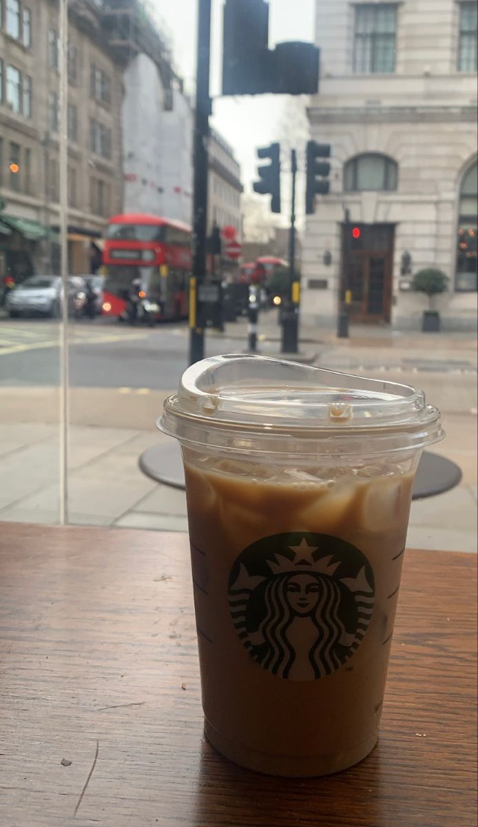 a cup of coffee sitting on top of a wooden table