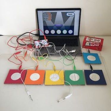 an open laptop computer sitting on top of a table next to some cords and wires