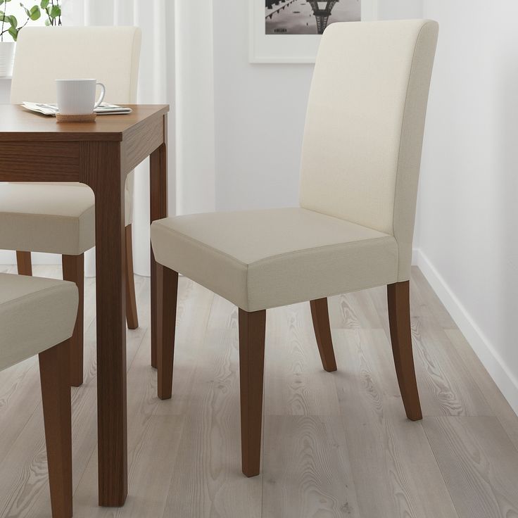 a dining room table with two chairs and a coffee cup on top of the table