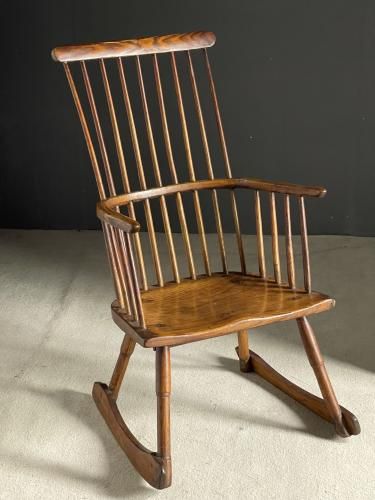 a wooden rocking chair sitting on top of a white floor