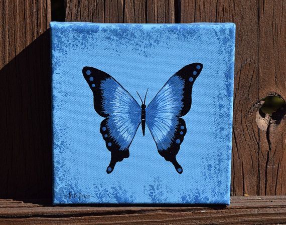 a painting of a blue butterfly on a wooden surface with a fence in the background