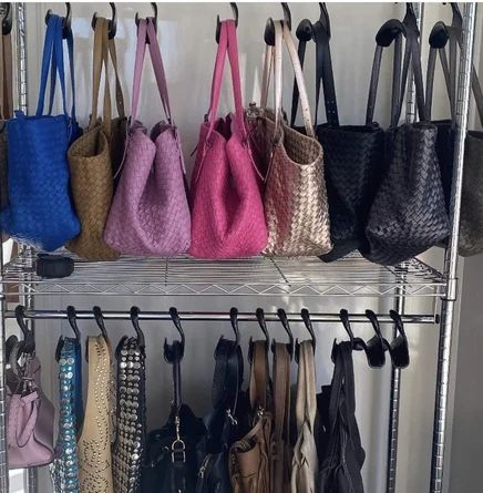 several purses and handbags are hanging on the rack