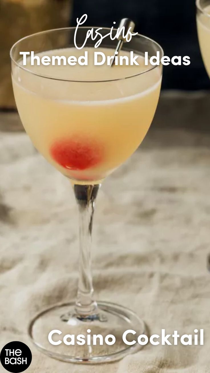 two glasses filled with drinks sitting next to each other on top of a tablecloth