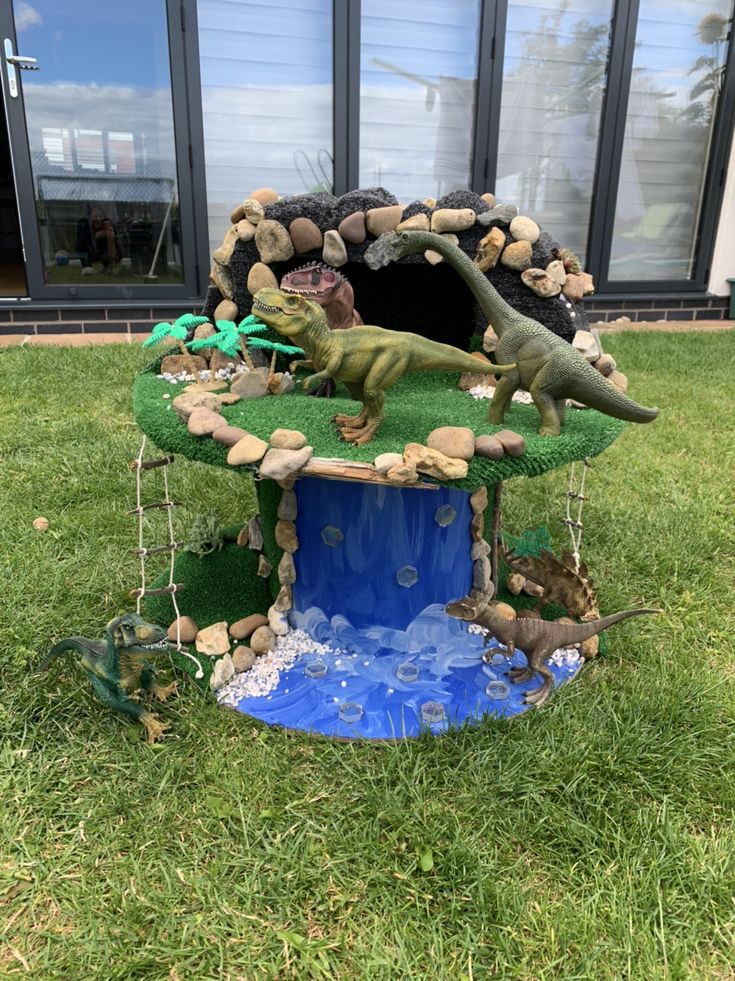 a toy dinosaur house in the grass