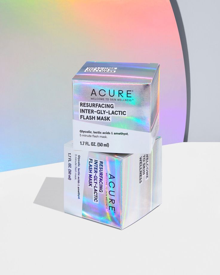 an acure cream box sitting on top of a white table next to a multicolored background