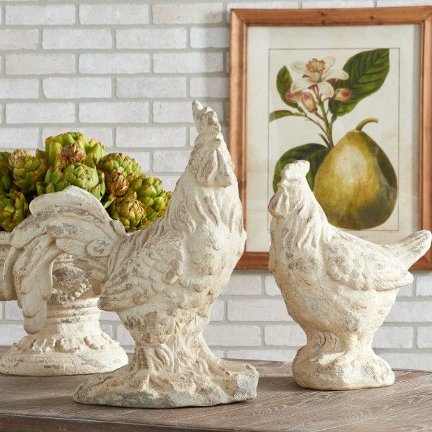 two ceramic chickens sitting on top of a wooden table