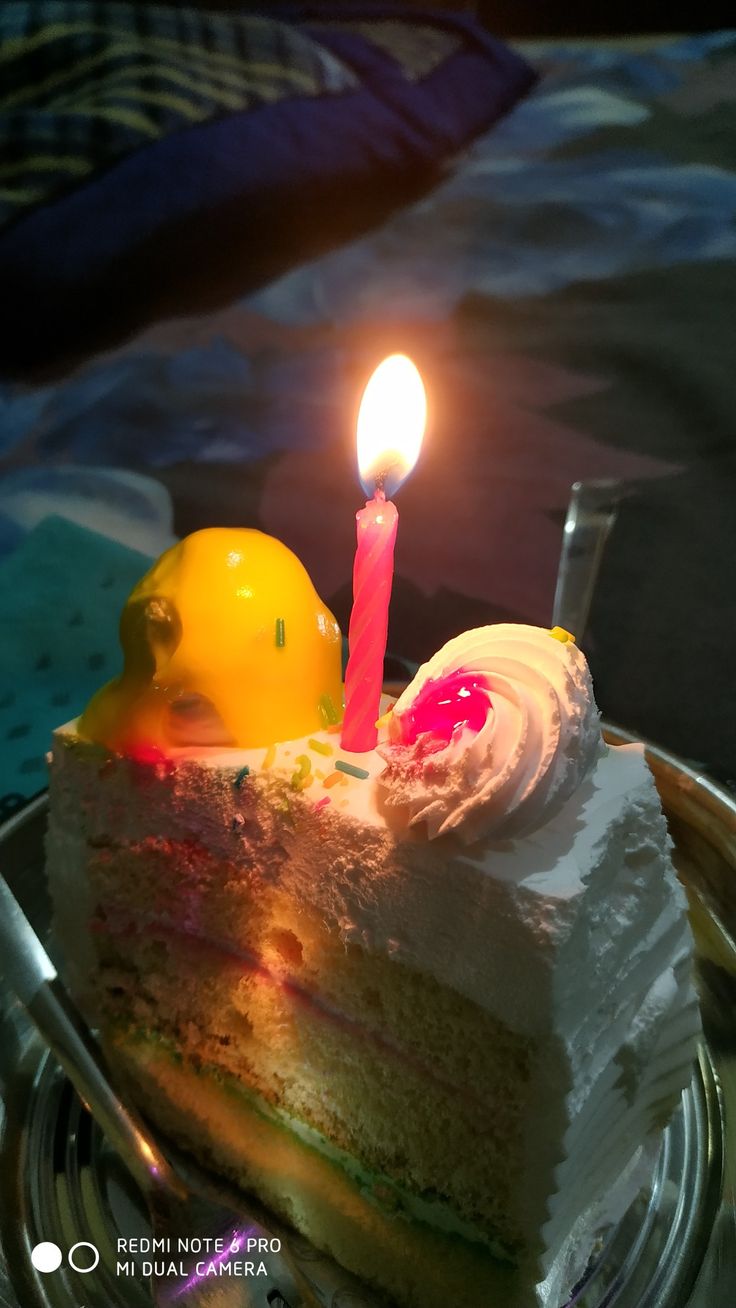 a slice of cake with a single candle on it