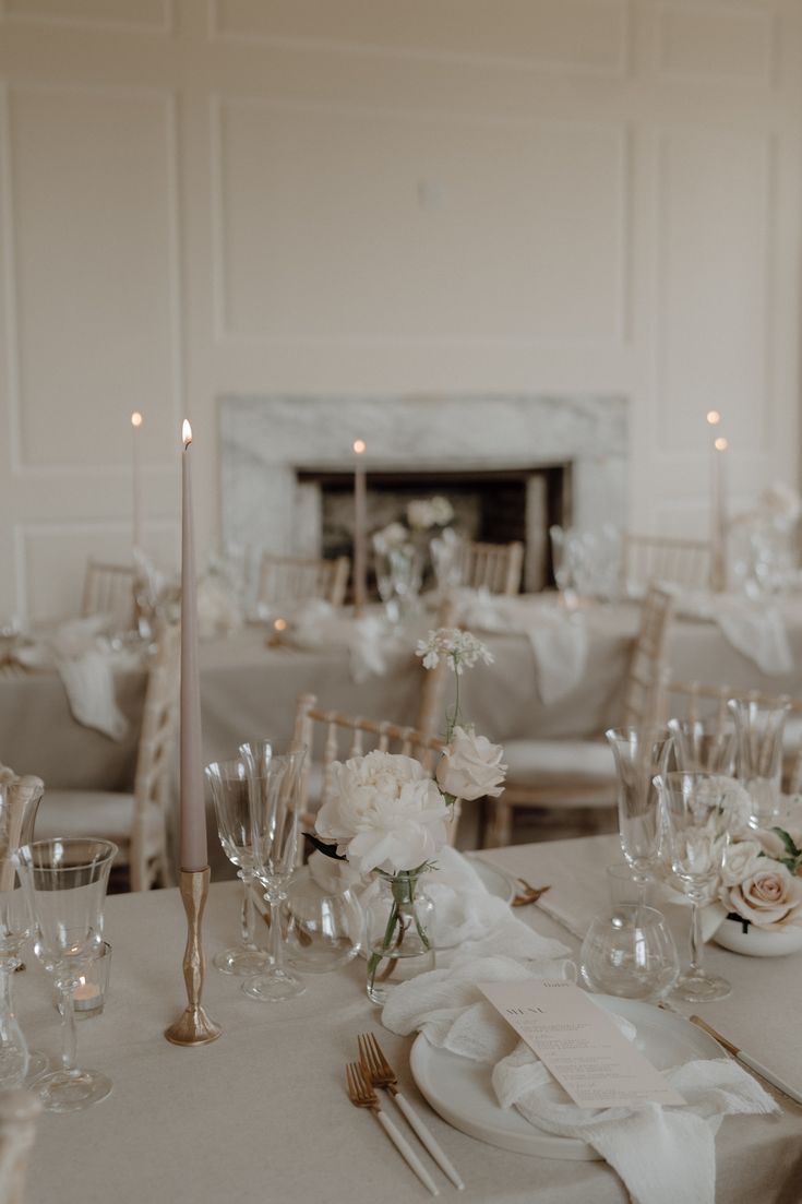 the table is set with silverware and white flowers