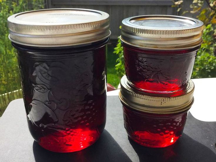 two jars filled with red liquid sitting on top of a table