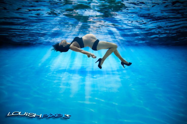 a woman is diving in the water with high heels