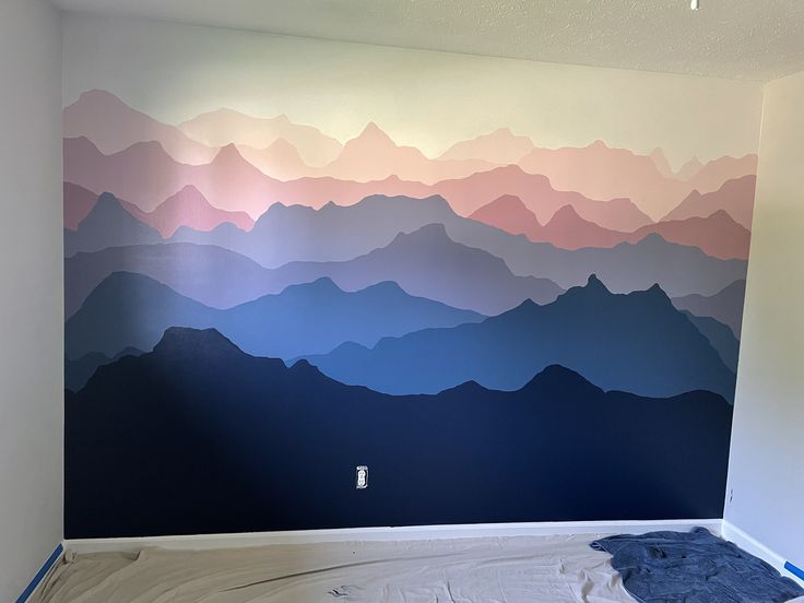 an empty room with mountains painted on the wall