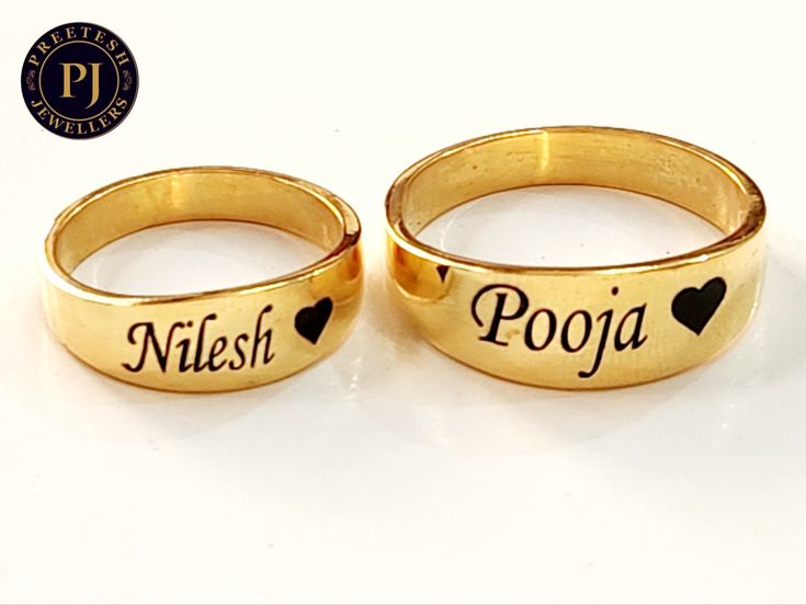 two gold rings with hearts and names on them