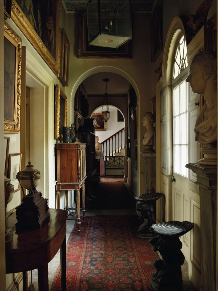 the hallway is decorated with antique furniture and paintings