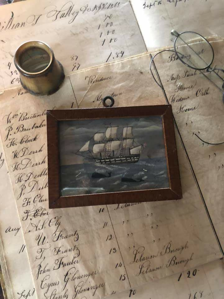 an old paper with writing on it and a painting of a ship in the middle