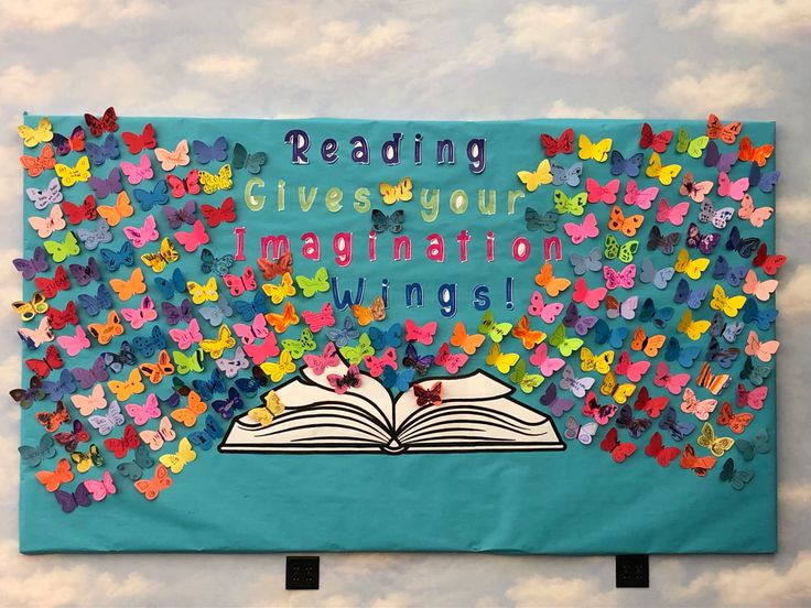 a bulletin board with butterflies and an open book