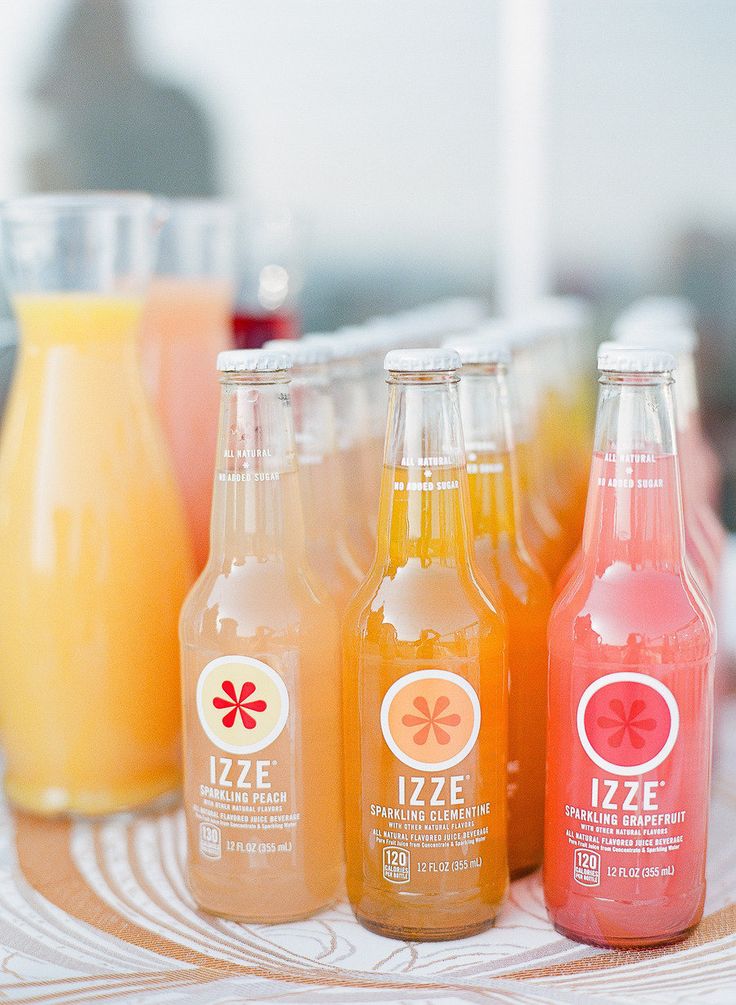 four bottles of juice are lined up on a table