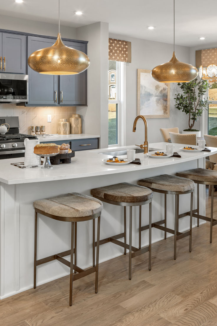 a kitchen with an island and stools next to the counter top in front of it