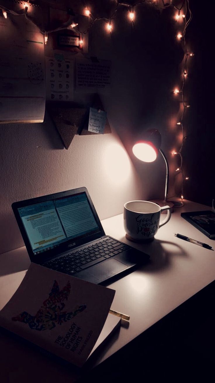 an open laptop computer sitting on top of a desk next to a cup of coffee