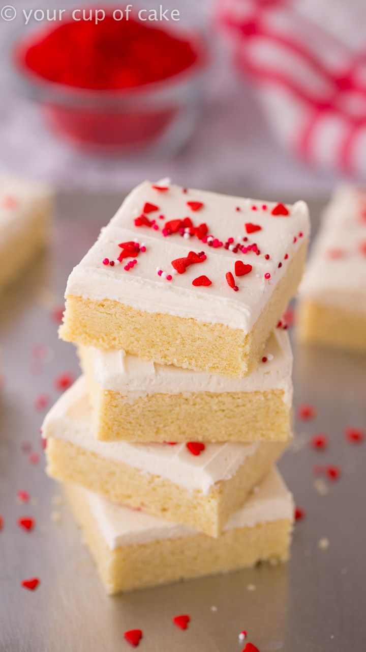 four pieces of cake with white frosting and red sprinkles