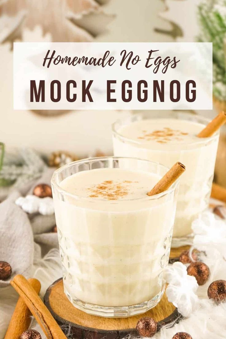 two glasses filled with eggnog on top of a wooden tray next to cinnamon sticks