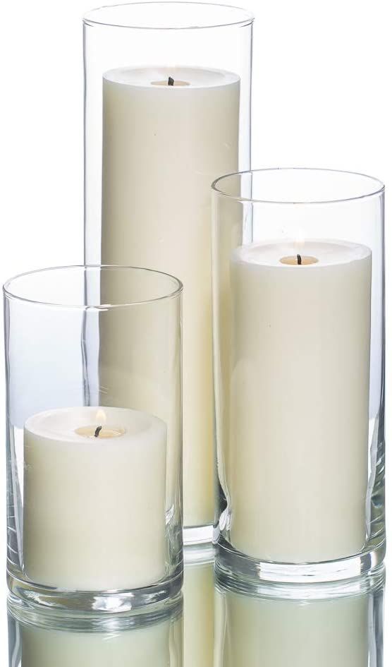 three white candles are sitting in glass vases