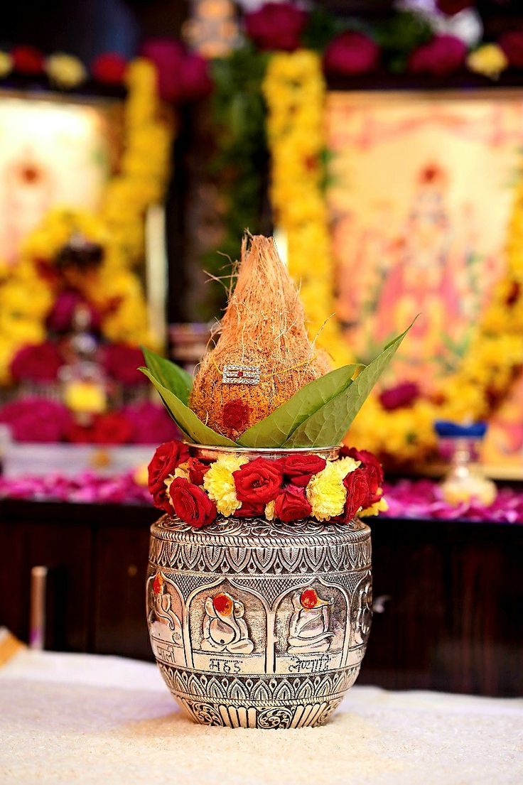 a vase filled with flowers on top of a white tablecloth covered table next to other floral arrangements