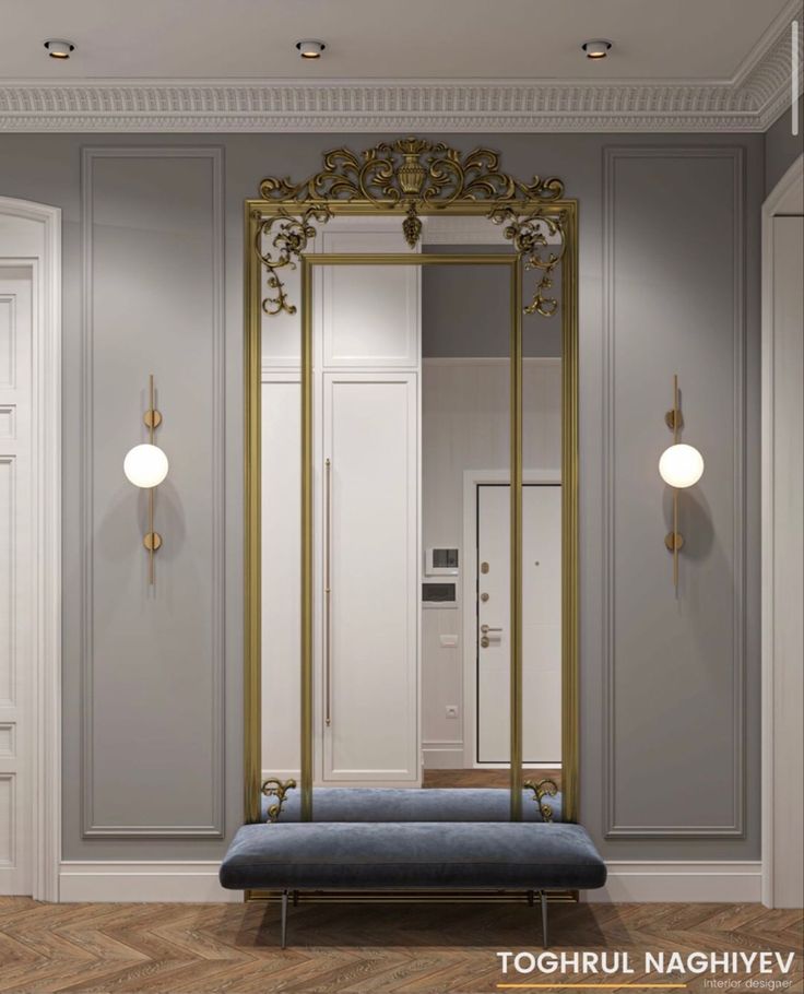 an ornate gold framed mirror in the corner of a room next to a blue bench