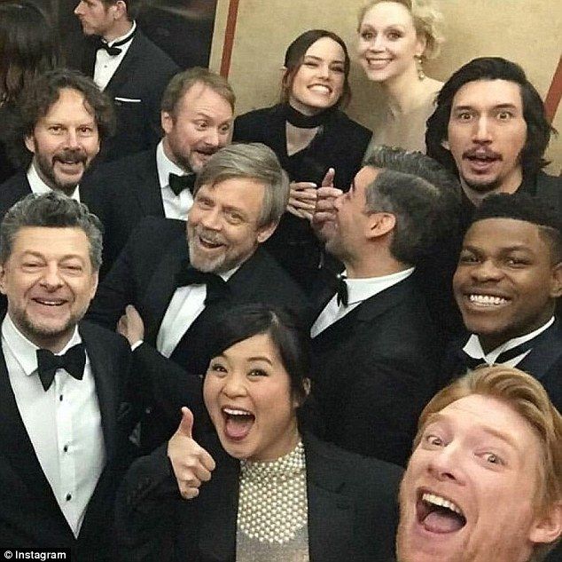 a group of people in tuxedos posing for a photo