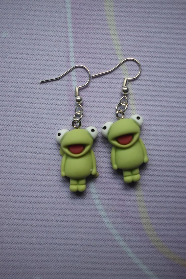 Bring a smile to your style with these Happy Frog Earrings! Featuring bright green frogs with cheerful expressions, these earrings are ideal for animal lovers or anyone who appreciates playful accessories. Lightweight and comfortable, these earrings are finished with silver-tone hooks. Green Frogs, Happy Frog, Frog Earrings, Funny Jewelry, Green Frog, Etsy Earrings Dangle, Animal Lovers, Bright Green, Jewelry Earrings Dangle