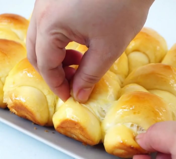 a person placing cheese on top of some bread