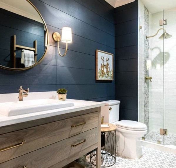 a white toilet sitting under a bathroom mirror next to a walk in shower and sink