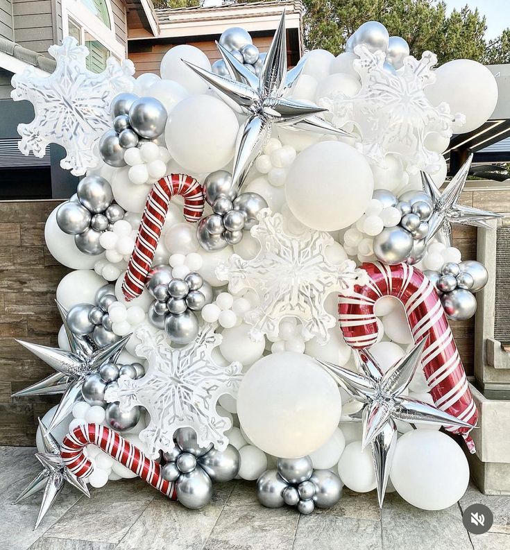 an outdoor christmas display with snowflakes, ornaments and candy canes on the ground