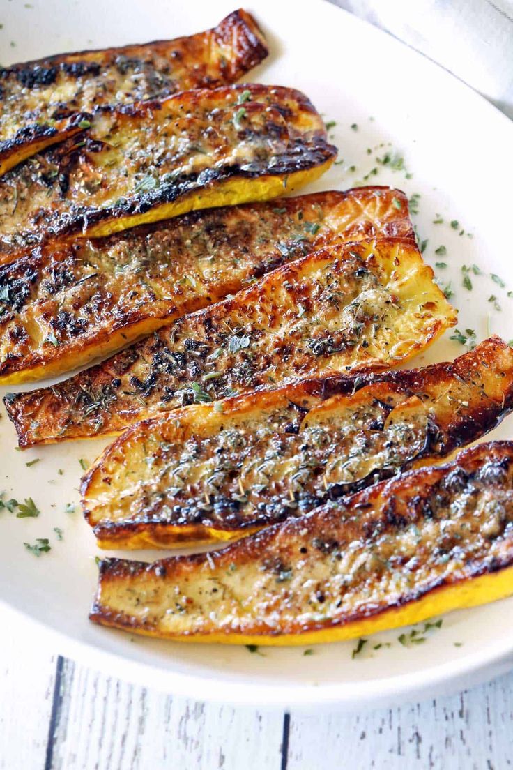 grilled eggplant on a white plate with parmesan cheese and herbs