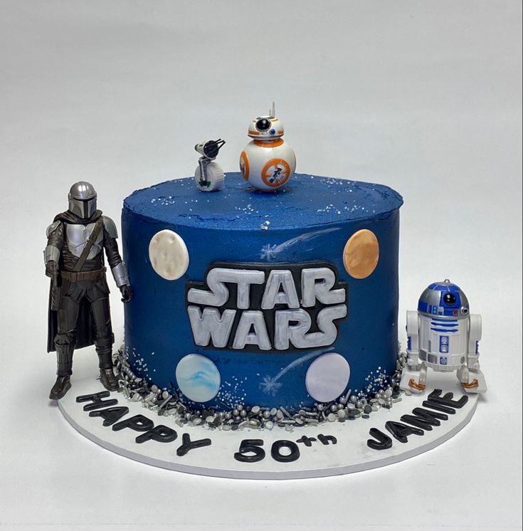 a star wars themed birthday cake with a robot and r2d2 figurine