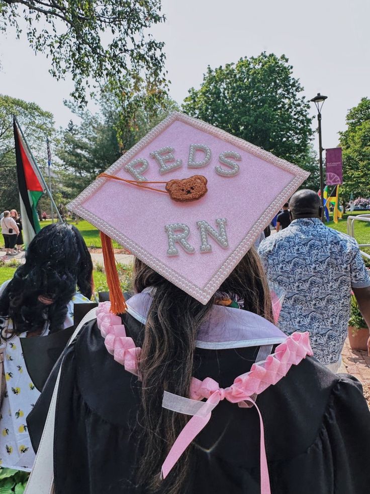 a woman wearing a graduation cap with the words reds run on it and a cookie