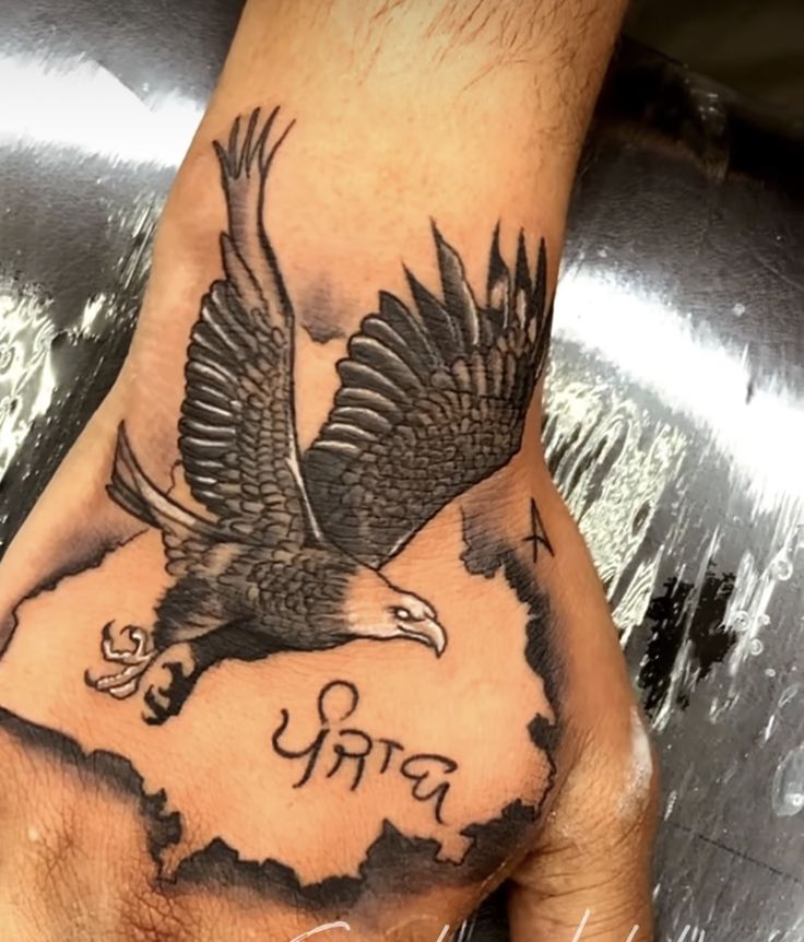 a hand with an eagle on it and the word india written in hebrew, is shown