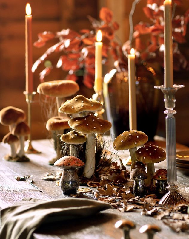 a table topped with lots of mushrooms next to candles