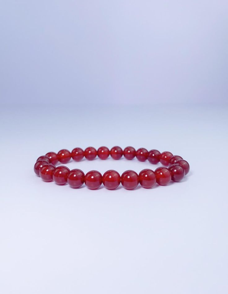 This carnelian bracelet is the perfect way to keep your energy high and your mood positive. The vibrant red stone is said to promote joy, happiness, and creativity, while also providing protection from negative energy. Wear it as a reminder to stay positive and focused on your goals. Red Spiritual Crystal Bracelet With Natural Stones, Spiritual Red Crystal Bracelet With Natural Stones, Red Carnelian Beaded Bracelet With Round Beads, Red Carnelian Beaded Bracelets With Round Beads, Red Carnelian Round Beads Bracelet, Red Meditation Bracelets With 8mm Beads, Red Bracelets With 8mm Beads For Meditation, Red Beaded Bracelets For Meditation 8mm, Elegant Red Beaded Bracelets For Meditation