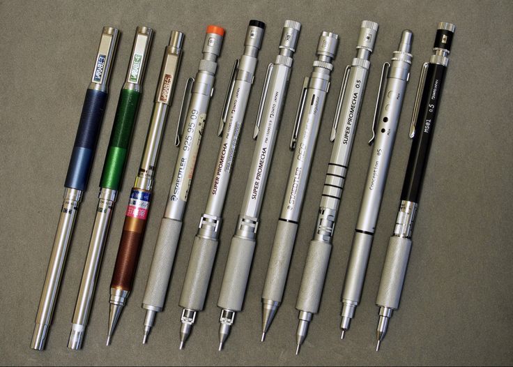 several pens are lined up next to each other on a table with one pen in the middle