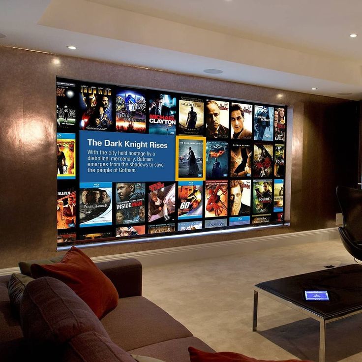 a living room filled with furniture next to a large window covered in movie posters on the wall