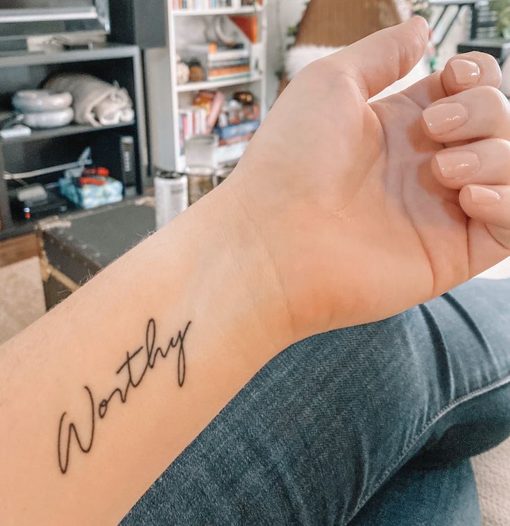 a woman's arm with the word nothing written on it in cursive font