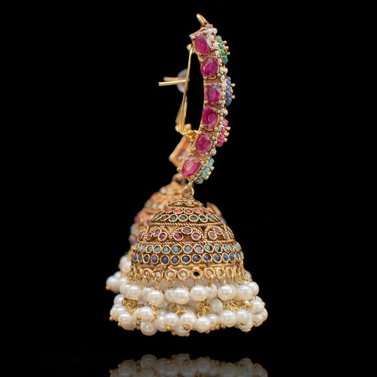 An entrancing ensemble defining a luxurious dream! A sensational pair of earrings depicting classic nauratan stones - perfectly complemented by traditional jhumki design with pearl moti finishing. Approximate earrings length is 3". Kindly click on the video for a detailed view of the product. Gold-plated on high-quality brass as base metal. Made by order. Kindly allow 5-7 weeks for the delivery of this item. For custom or urgent requests, please contact support@alacouture.com. *Please Note: The Multicolor Chandbali Jhumkas With Intricate Design, Elegant Designer Stone Work Jhumkas, Elegant Designer Chandbali Jhumkas, Diwali Temple Jewelry Pearl Earrings With Stone Work, Temple Jewelry Pearl Earrings With Stone Work, Elegant Chandbali Earrings For Designer Wear, Elegant Chandbali Designer Earrings, Elegant Designer Chandbali Earrings, Elegant Meenakari Earrings For Designer Wear