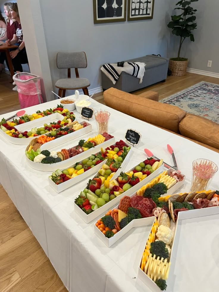 there are many trays of different types of food on the table in this room