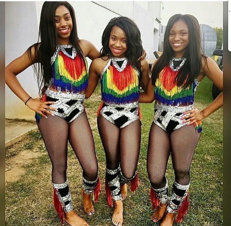 three beautiful women in colorful outfits posing for the camera